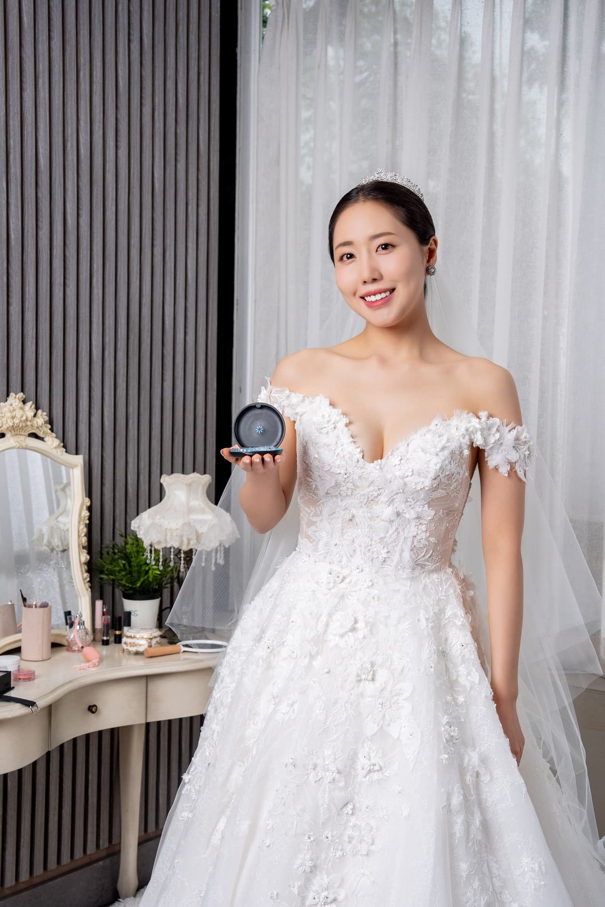웨딩드레스를 입고 투명 교정장치 케이스를 손에 든 성인 모델