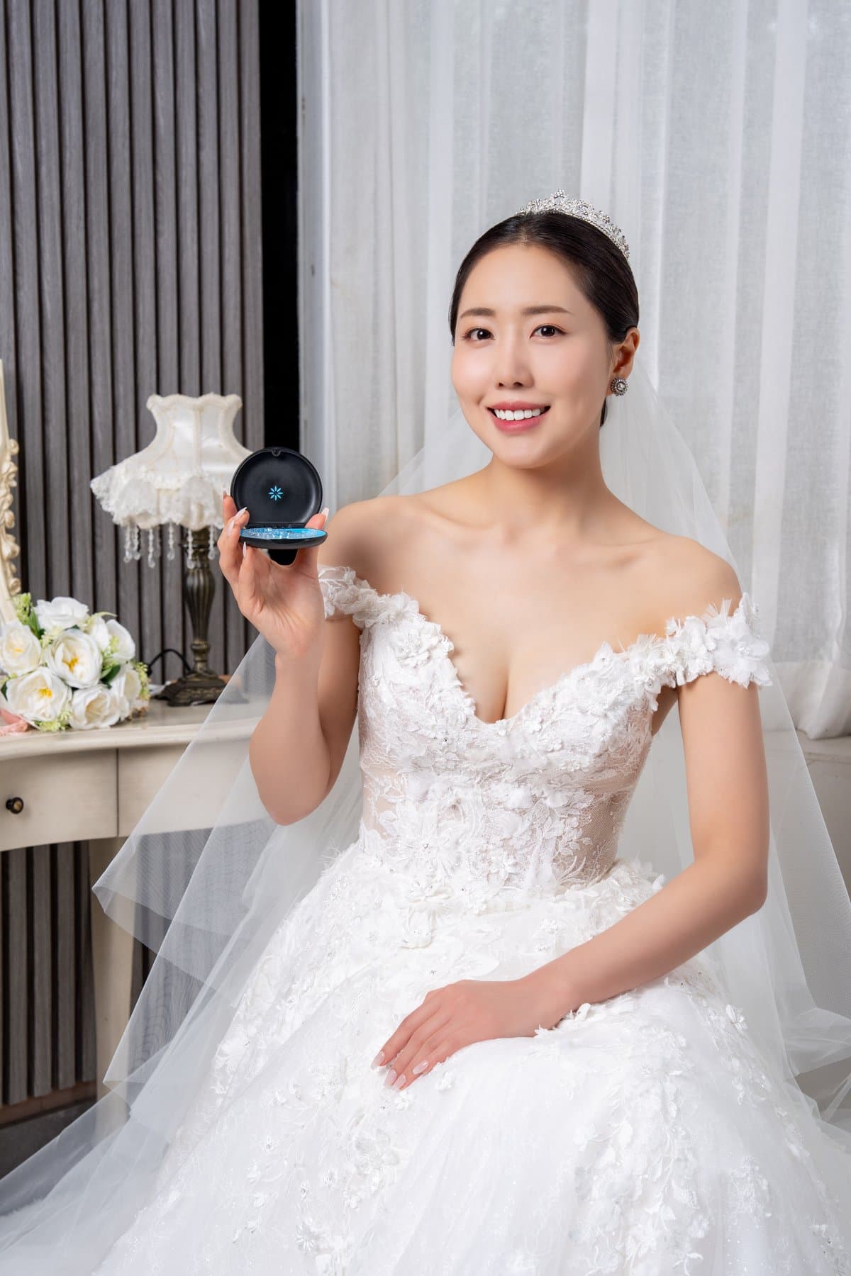 웨딩드레스를 입고 투명 교정장치 케이스를 든 성인 모델